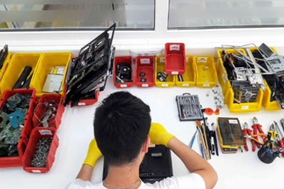 A technician recovering data from a damaged hard drive using specialized software.