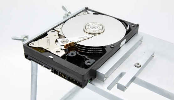 Close-up of a hard drive in a cleanroom environment, with specialized tools and equipment arranged around it for data recovery and repair.