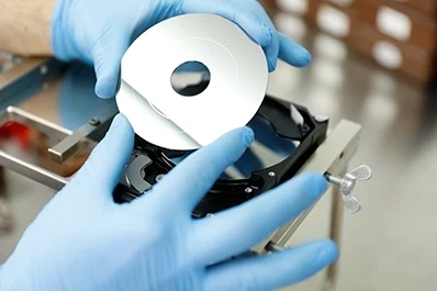 HDD disc being serviced in a cleanroom environment to prevent contamination.